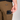 A close-up of a person wearing brown pants with a black textured phone case tucked into the back pocket. The brand label 'HANDUP' is visible on the pocket.