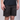 A person wearing dark charcoal shorts with a distressed, scuffed texture and a black t-shirt, shown from the chest down against a light gray studio background.