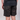 A person wearing dark camouflage shorts and a black t-shirt, shown from the waist down against a light gray studio background.