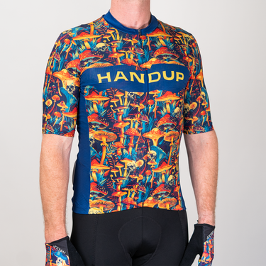 Cycling jersey with colorful mushroom pattern and 'HANDUP' branding on a gray background