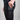Person wearing black leggings with a visible brand logo, holding a phone.