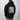 Person wearing a black hoodie with a graphic design on the back against a plain background
