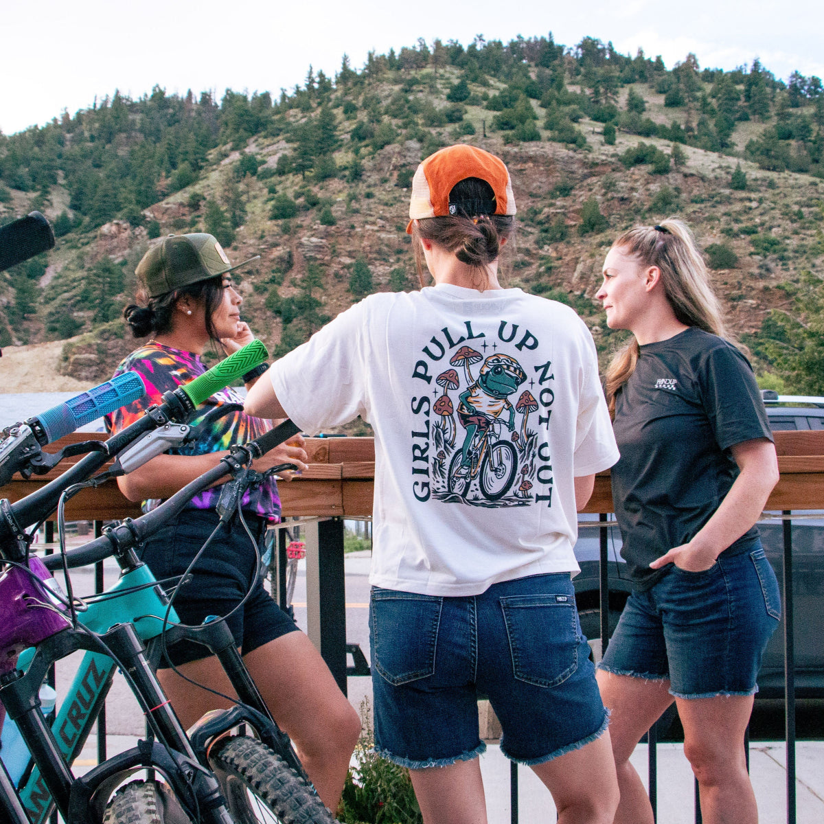 Three women with bicycles in a mountainous area