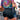 Person wearing a tie-dye shirt and black shorts with a blurred background