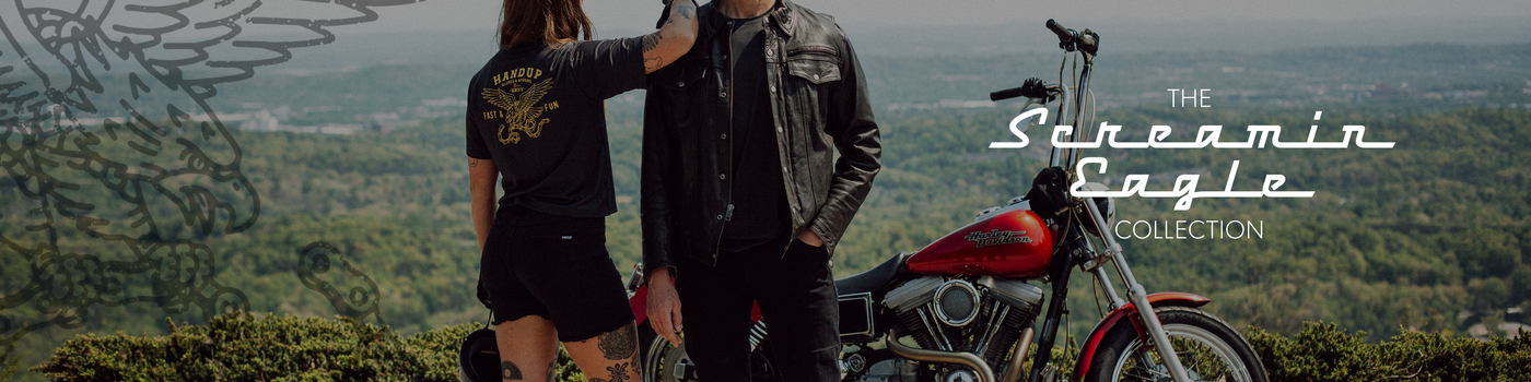 Two people standing next to a motorcycle with a scenic background, featuring 'The Screaming Eagle Collection' branding.